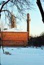 Old red brick pipe with stairs and observation platform, residential district with houses, winter snowy street Royalty Free Stock Photo