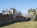 Old red brick wall of country cemetery at village Cvikov in luzicke hory, Lusatian Mountains, spring trees, blue sky Royalty Free Stock Photo