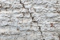 Old red brick wall covered with a white plaster and a large cracked. Texture background Royalty Free Stock Photo