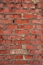 An old red-brick wall with fallen gray plaster.