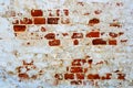 An old red brick wall with fallen off white plaster. Royalty Free Stock Photo