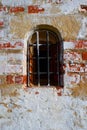 An old red brick wall with fallen off white plaster.