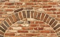 Old red brick wall texture with arch.