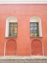 An old red brick wall and two green windows Royalty Free Stock Photo