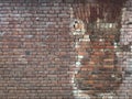 Old red brick wall with a window pane, restored by stones of the same type Royalty Free Stock Photo
