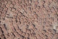 Old, red bricks arranged in a circle. Cobblestone. Texture, embossed background