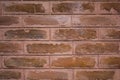 A Old red brown pink brick wall with smooth seams of cement. rough surface texture Royalty Free Stock Photo