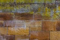 Old red brown sandstone wall with colorful lichen and moss for background Royalty Free Stock Photo