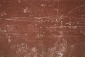 A old red-brown wall with deep white scratches and stains. rough texture.