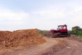 Red bulldozer outdoors. An excavator stands among gravel, stones and earth in a quarry.
