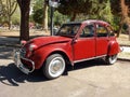 old red burgundy popular Citroen 3CV 1960-1979 in the street in front of a park. Classic car show. Royalty Free Stock Photo