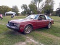 Old red Toyota Celica Series B coupe circa 1980 on the lawn. Nature, grass, trees. Classic car show Royalty Free Stock Photo