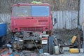 Old red cabin of a broken truck and spare parts on the street in a dump Royalty Free Stock Photo