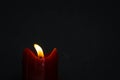 Old red candle with glimmer light flame on nice grey background, with blank upper space Royalty Free Stock Photo