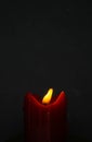 Old red candle with glimmer light flame on nice grey background, with blank upper space Royalty Free Stock Photo