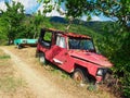 Old Red Car and Green Trailer Abandoned in Rural Area