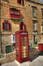 An old red cardphone booth in the historic city Valletta with an old appartment building in the background Royalty Free Stock Photo