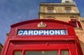 An old red cardphone booth in the historic city Valletta with an old appartment building in the background Royalty Free Stock Photo