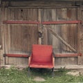 an old red chair against an old wooden wall. Antique furniture Royalty Free Stock Photo