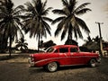 Old red classic cuban car and some palms Royalty Free Stock Photo