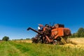 Old red combine harvester working in a wheat field Royalty Free Stock Photo