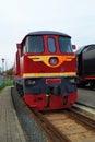 Old red diesel engine locomotive at the railway station. Vintage train staying on the railroad.