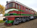 Old red diesel engine locomotive at the railway station. Vintage train staying on the railroad.