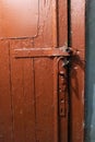 Old red door with a handle and uneven rough surface close-up