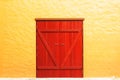 Old red door in yellow wall Royalty Free Stock Photo