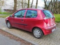 Old red Fiat Punto two doors back view parked