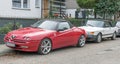 Old red Alfa Romeo Spider with uncommon design sport car and Saab 900 Turbo parked Royalty Free Stock Photo
