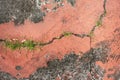 Old red grunge cracked floor of cement and stone with grass growing, rough texture background Royalty Free Stock Photo