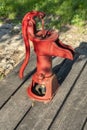 Old red hand water pump mounted on wood planks Royalty Free Stock Photo