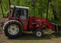An old red International tractor with a bucket Royalty Free Stock Photo