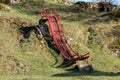 Old red metal playground slide on grassy hillside Royalty Free Stock Photo