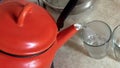 Old Red Metal Teapot. Pouring Heating Water In the Glass