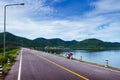 Old red motorcycle park by lake with summer sky and mountain Royalty Free Stock Photo