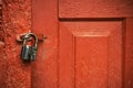 Old red painted door with metal open padlock Royalty Free Stock Photo