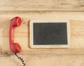 Red old fashioned telephone receiver on wooden table Royalty Free Stock Photo