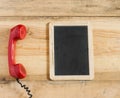 Red old fashioned telephone receiver on wooden table Royalty Free Stock Photo