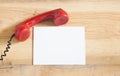 Red old fashioned telephone receiver on wooden table Royalty Free Stock Photo