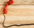 Red old fashioned telephone receiver on wooden table Royalty Free Stock Photo