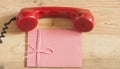 Red old fashioned telephone receiver on wooden table Royalty Free Stock Photo