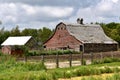 An old red hip roofed barn in serious deterioration