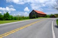 Old red roof barn near highway Royalty Free Stock Photo