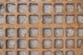 Old red rusty metal sewer manhole with checkered pattern. rough surface texture Royalty Free Stock Photo