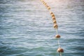 Old red styrofoam buoys on the rope lying on the beach of the sea