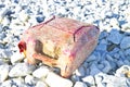 Old red tank abandoned in a pebbles seashore