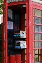 Old Red Telephone Box with a Pile of Books For People to Borrow.