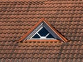 Old red tiled roof and triangular window